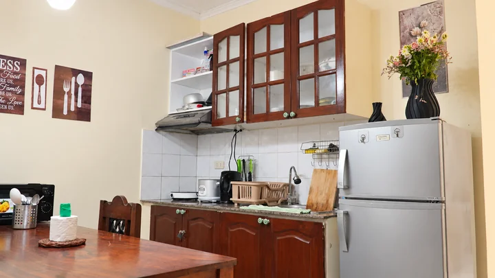 Private kitchen with refrigerator, cooking appliances, sink, and dining table